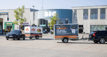 Two cars pulling branded Freetrailer trailers in front of the BIG Shopping center in Herlev, Denmark—one promoting MAX Burgers and the other POWER. A visual example of how businesses can increase exposure and foot traffic through branded trailers.